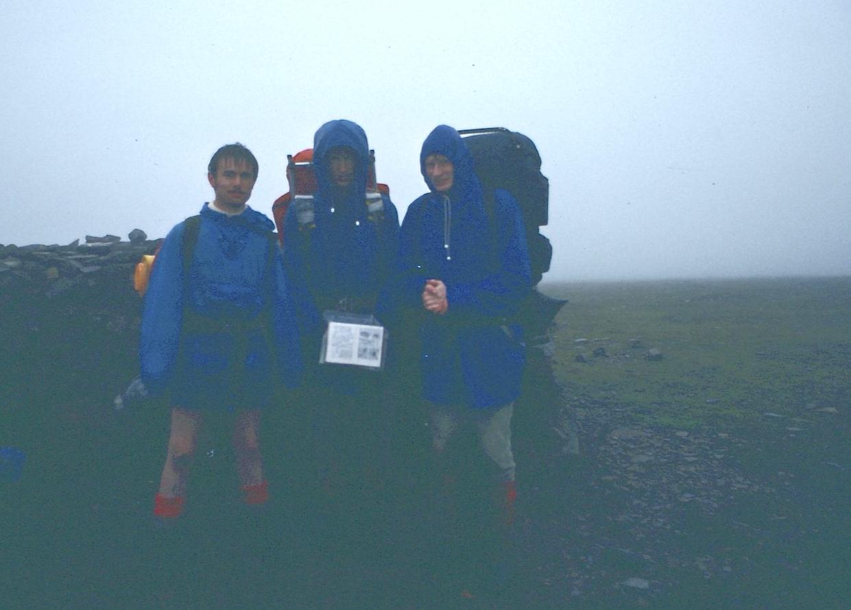 The lads atop Cross Fell. In the map case you can see  Wainwright’s Pennine Way Companion opened to pages 54 and 55.